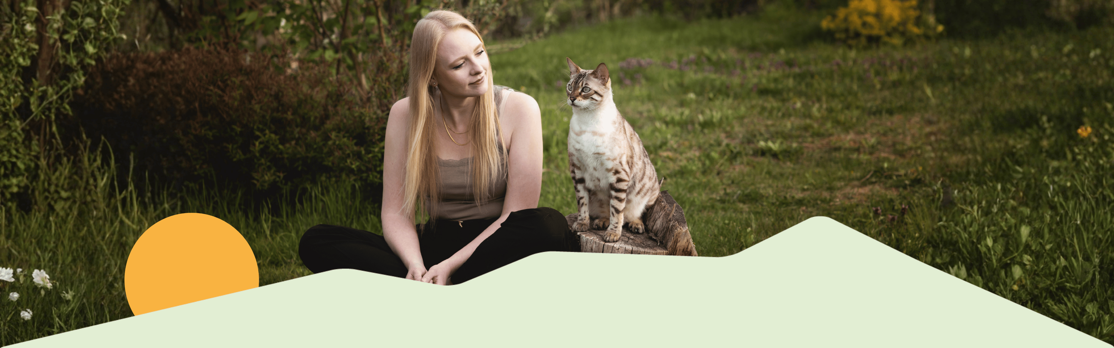 Katze sitzt im Wald auf einem Baumstamm neben ihrer Besitzerin